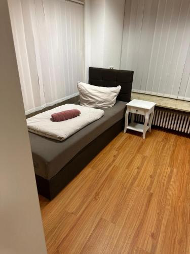 een klein bed in een kamer met een houten vloer bij Apartment 1 in Stockach