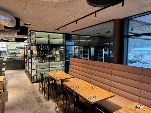 ein Esszimmer mit Holztischen in einem Restaurant in der Unterkunft Modern Alpine Apartment Corso Harrachov in Harrachov