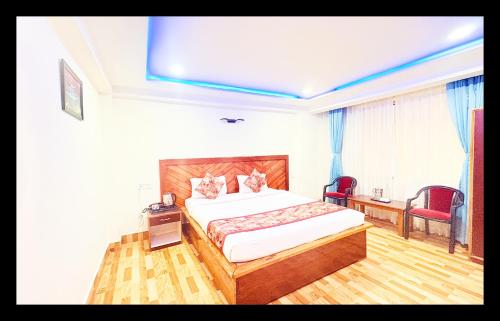 a hotel room with a bed and a desk and chairs at The Golden And SPA in Pelling