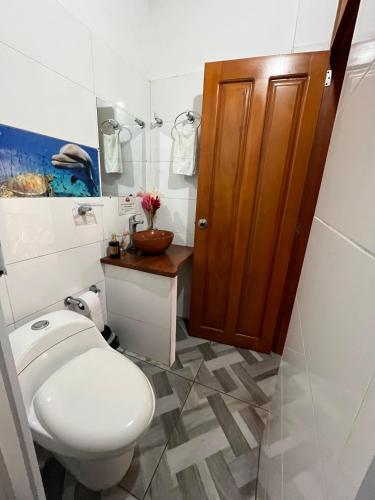 a bathroom with a toilet and a wooden door at Cabañas Arrecifes in El Valle