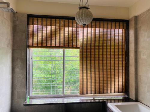 ein Badezimmer mit großem Fenster mit Badewanne und Waschbecken in der Unterkunft Oasis Residency and Resorts in Solapur