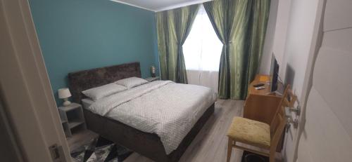a small bedroom with a bed and a window at Apartament Central in Câmpina