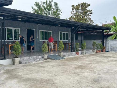 a group of people standing outside of a house at J House Has Love in Sukhothai