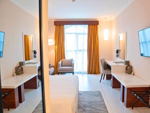 a room with two desks and a mirror at Asma Hotel Al Barsha in Dubai