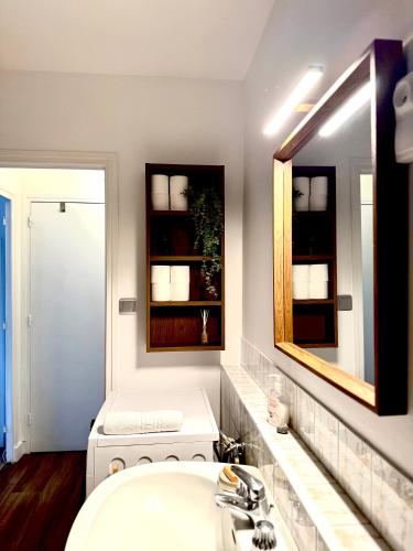 ein Badezimmer mit Waschbecken und Spiegel in der Unterkunft Studio lumineux avec terrasse à deux pas de Genève in Gaillard