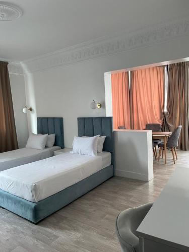 ein Schlafzimmer mit zwei Betten und einem Schreibtisch und einem Tisch in der Unterkunft Crystal in Tangier