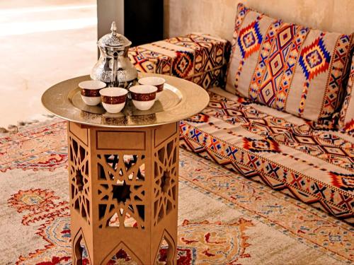een tafel met kopjes erop naast een bank bij Asma Hotel Al Barsha in Dubai