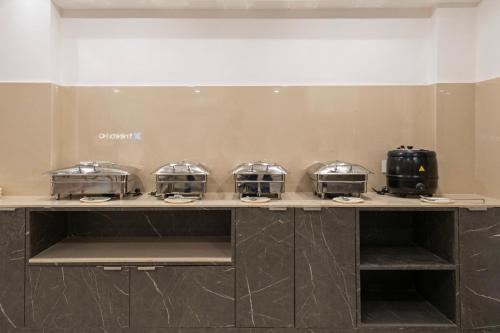 een toonbank met vier broodroosterschalen erop bij Treebo Premium Hydotel Gachibowli in Hyderabad