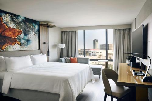 a hotel room with a large white bed and a desk at Chicago Marriott Oak Brook in Oak Brook