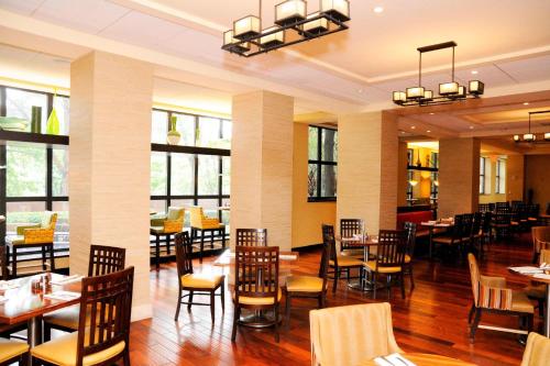 a dining room with tables and chairs and windows at Chicago Marriott Suites O'Hare in Rosemont