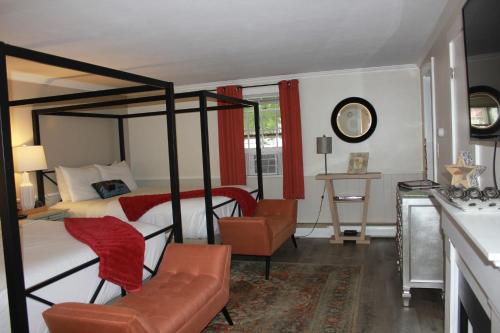 a bedroom with a four poster bed and a chair at Scenic Vista Inn in North Conway