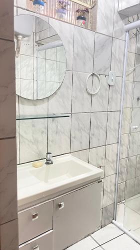a bathroom with a sink and a mirror at Descanso e aconchego in Aparecida