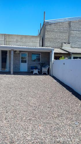 a house with a bench in front of a building at Casa da Praia Capão da Canoa in Capão da Canoa