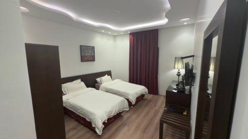 的黎波里فندق الجرات的有两张床和一面镜子的酒店房间