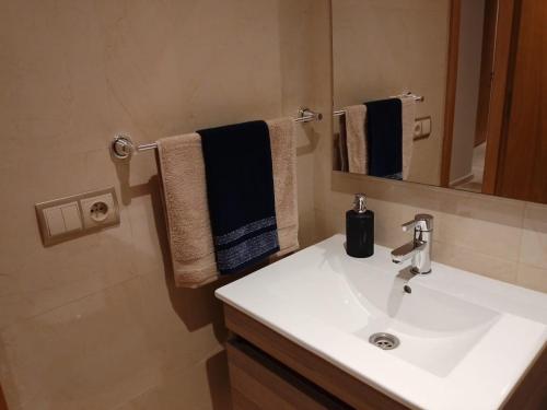 a bathroom with a sink and a mirror and towels at Les belles loges in Bouskoura