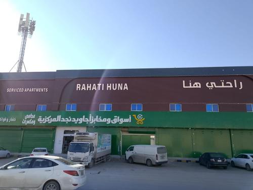 ein Gebäude mit auf einem Parkplatz geparkten Autos in der Unterkunft راحتي هنا 7 in Riad