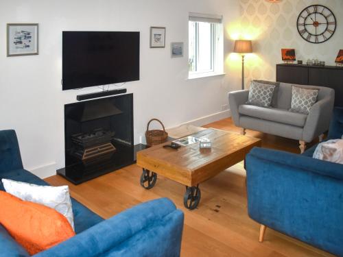 ein Wohnzimmer mit Sofas, Tisch und Fernseher in der Unterkunft Bracken Lea in Barbrook