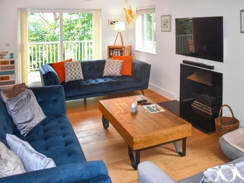 ein Wohnzimmer mit 2 blauen Sofas und einem Couchtisch in der Unterkunft Bracken Lea in Barbrook