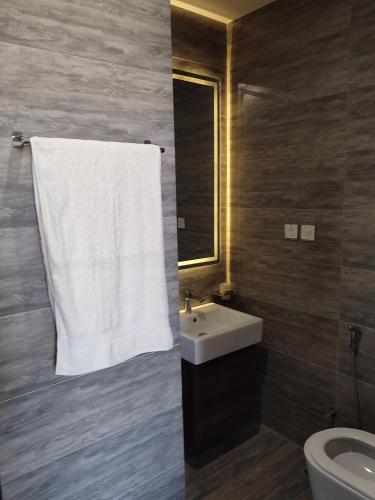 a bathroom with a sink and a white towel at Sky Park Nest in Islamabad