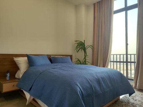 a bedroom with a blue bed and a window at Sky Park Nest in Islamabad