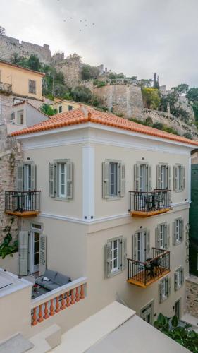 a white building with balconies on a hill at Onora Suites Nafplio in Nafplio