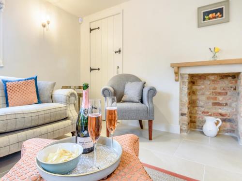 een woonkamer met een tafel met twee glazen wijn bij Halton Lodge in Spilsby