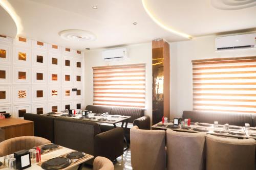 Un restaurante con mesas y sillas en una sala. en Hotel MakeSure, en Ajmer