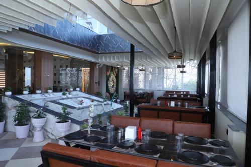 Un restaurante con una mesa y una estufa en una habitación. en Hotel MakeSure, en Ajmer