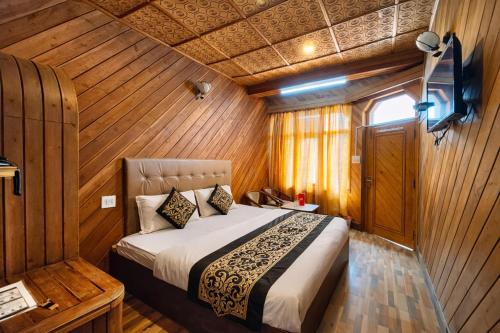 ein Schlafzimmer mit einem Bett in einem Holzzimmer in der Unterkunft Hotel Naini -Lake -View Near The Mall Road - Restaurant And Free Wifi All Rooms - Prime Location - Best Hotel in Nainital