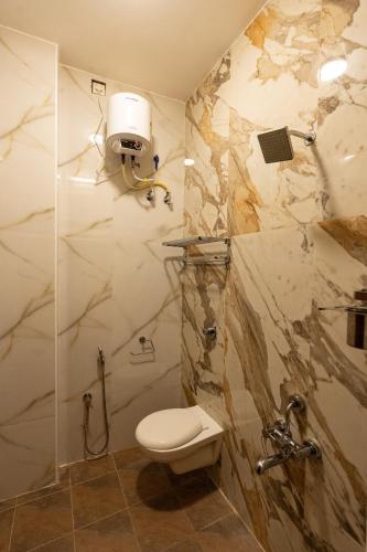 a bathroom with a toilet and a shower at SK Grand Palace in Pondicherry