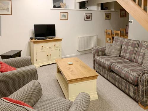 een woonkamer met twee banken en een tv bij The Chapel in Staveley