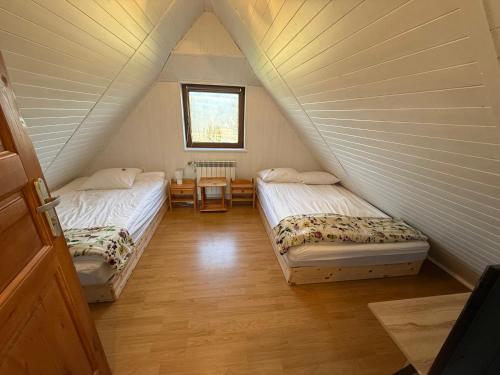 een kamer met 2 bedden op een zolder bij Spacerowy Zakątek in Ślemień