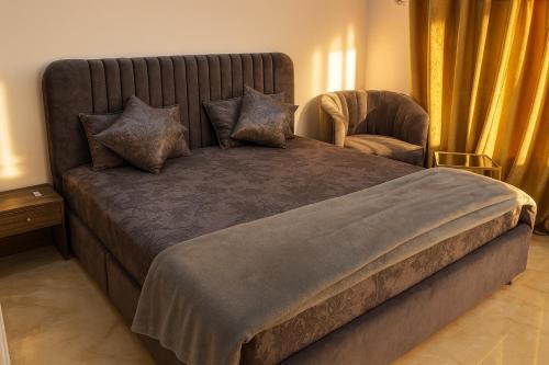 een slaapkamer met een groot bed en een stoel bij The Canvas Stay in Islamabad