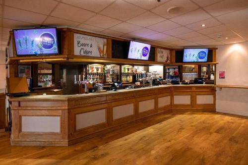 a bar with several televisions on the wall at Suntrail House in Great Clacton