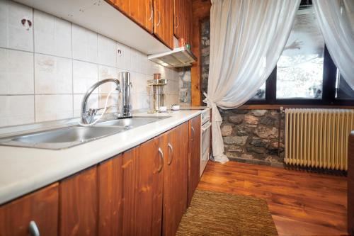 una cucina con un lavandino e una finestra di Loutra Mountain Nature a Aridaía