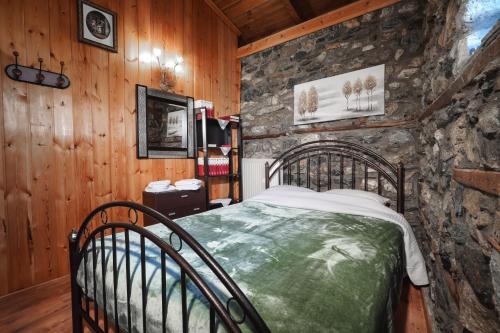 una camera da letto con un letto in un muro di pietra di Loutra Mountain Nature a Aridaía