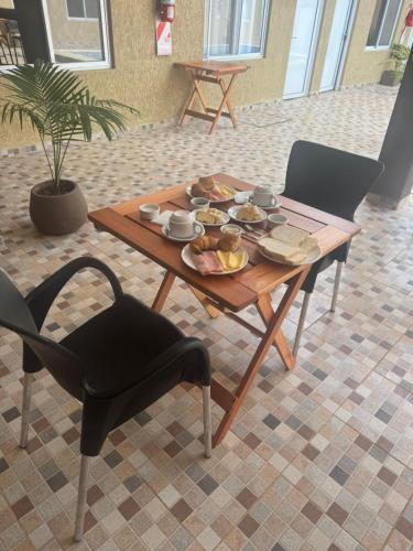 a wooden table with a plate of food on it at Hotel Boutique Porá Iguazú in Puerto Iguazú