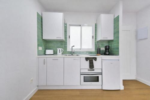 una cucina con mobili bianchi e un lavandino di Palm Suites a Puerto Rico de Gran Canaria