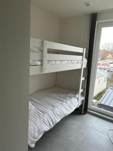 a room with two bunk beds and a window at Samen Aan Zee in Oostduinkerke