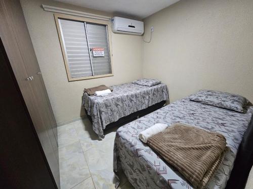 En eller flere senge i et værelse på O 353 Apartamento mobiliado completo 02 quartos com garagem