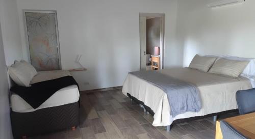 une chambre avec un lit et une chaise dedans dans l'établissement Cabañas Don Ricardo, à Dolores