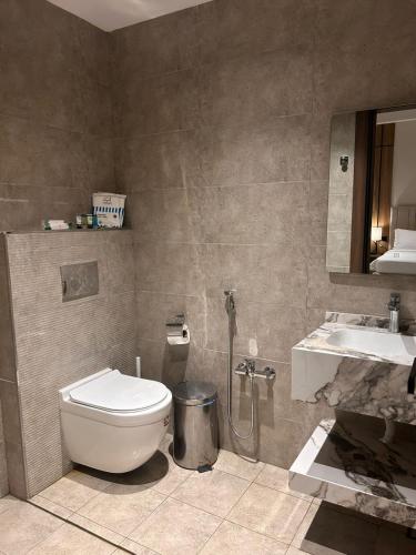 a bathroom with a toilet and a sink at هيلز للشقق المخدومة in Hail