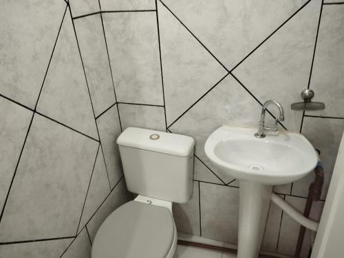 een badkamer met een wit toilet en een wastafel bij Alojamento seu Jorge in Campinas