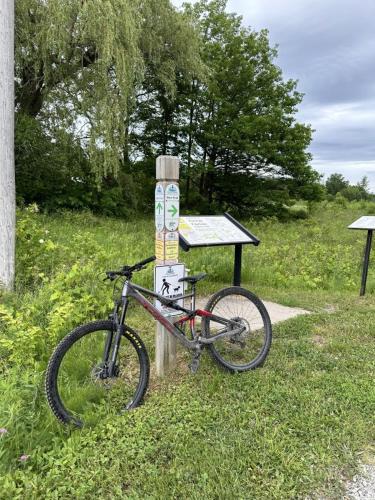 Ein Fahrrad, das neben einem Schild im Gras geparkt ist in der Unterkunft 19th Hole Hideaway in Collingwood