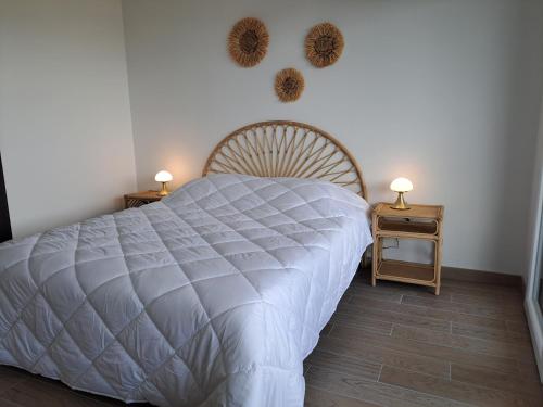 ein Schlafzimmer mit einem weißen Bett und zwei Nachttischen in der Unterkunft Iconic 343 , Superbe T2 climatisé, wifi, parking, terrasse 18m2 in Cap d'Agde