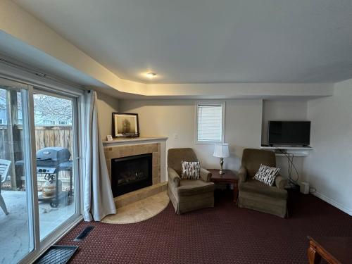 ein Wohnzimmer mit zwei Sesseln und einem Kamin in der Unterkunft 19th Hole Hideaway in Collingwood