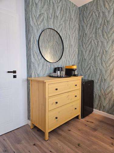 a wooden dresser with a mirror on a wall at Mountain View Amza Accomodation in Râşnov