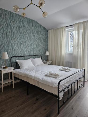 a bedroom with a bed and a green wall at Mountain View Amza Accomodation in Râşnov