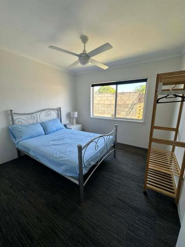 een slaapkamer met een bed met een plafondventilator bij Gold Coast Rooms in Gold Coast