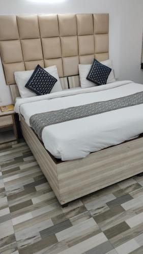 ein Schlafzimmer mit einem großen Bett mit großem Kopfteil in der Unterkunft Hotel Peeramant Near IGI Airport in Jāmb